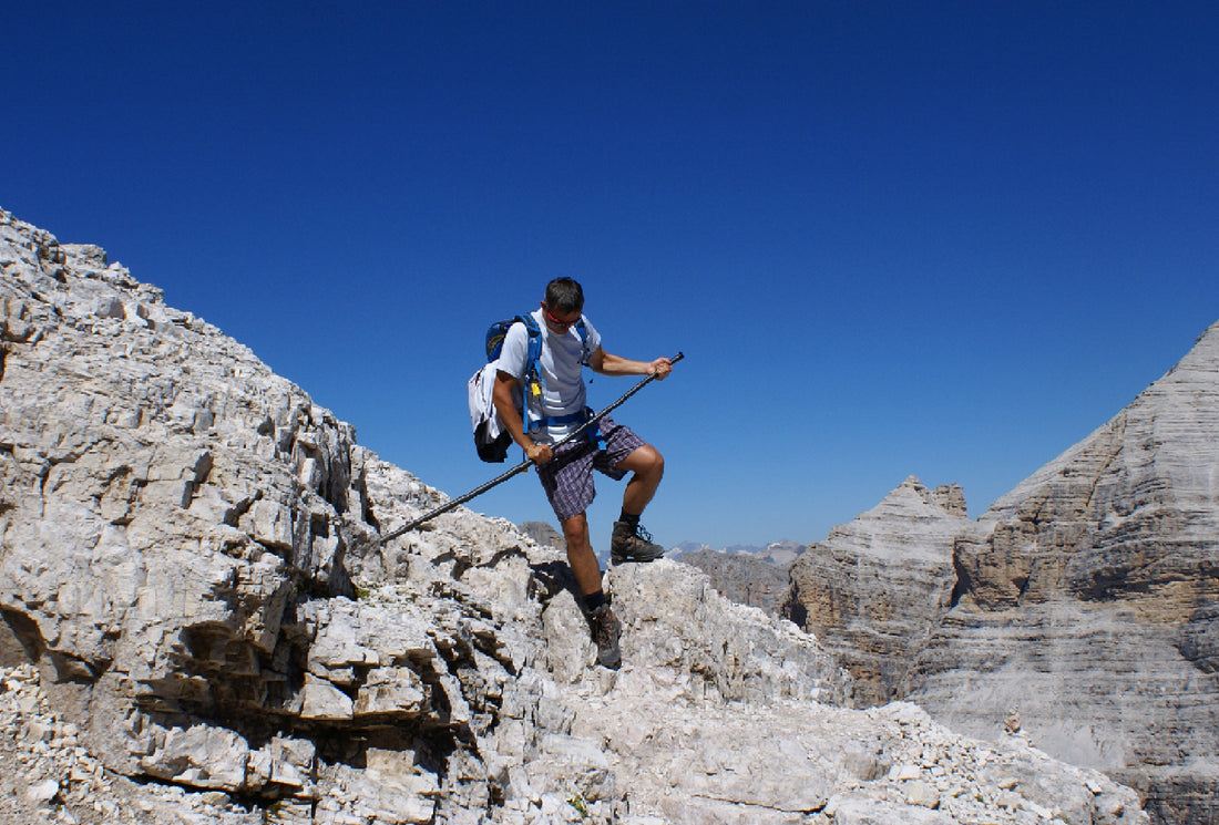Ein Mann beim Abstieg von einem Berg-Grat nutzt den Mountrainer um sich abzustützen